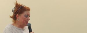 speaker at a council meeting discussing funding cuts