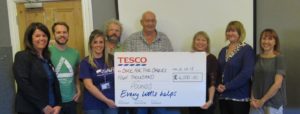 photo of carers holding large cheque dontation from Tesco