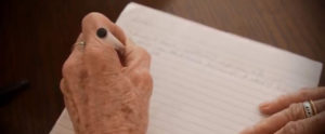 photo of someone writing with pen