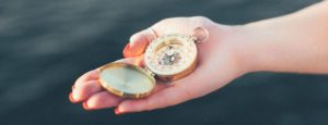 photo of hand holding a compass
