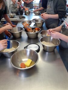 An image from a young carers activity in East Sussex, showing the hands of young carers during the cooking activity.