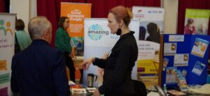 Two people talking at a conference in front of banners