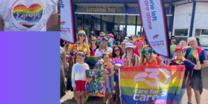 Care for the Carers supporters at the Eastbourne Pride parade, standing at the pier.