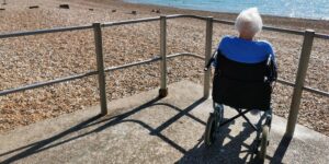 Person in a wheelchair looking out to sea